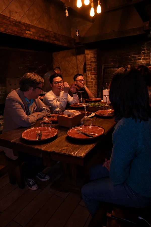 Guests sharing a meal beneath warm pendant lights