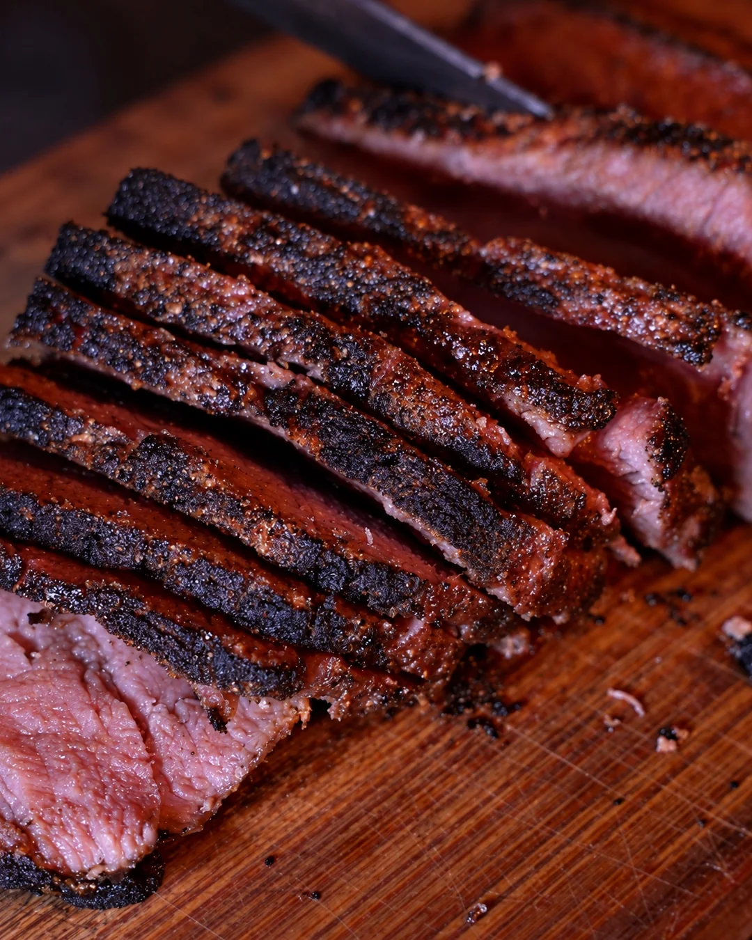 Sliced fire-grilled steak on a wooden board